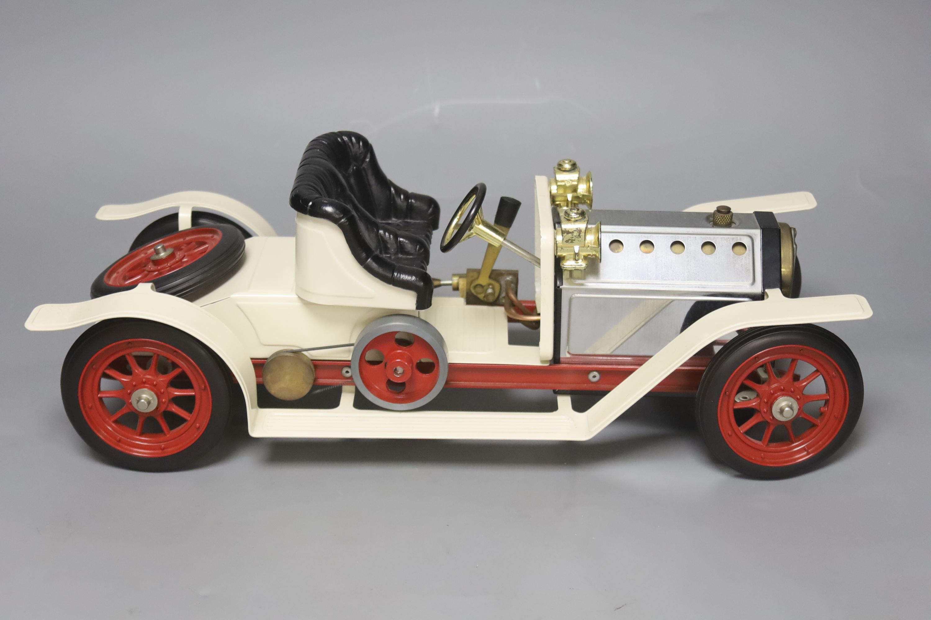 A Mamod live steam vintage two-seater roadster, with silver and cream paintwork and red wheels, oil can